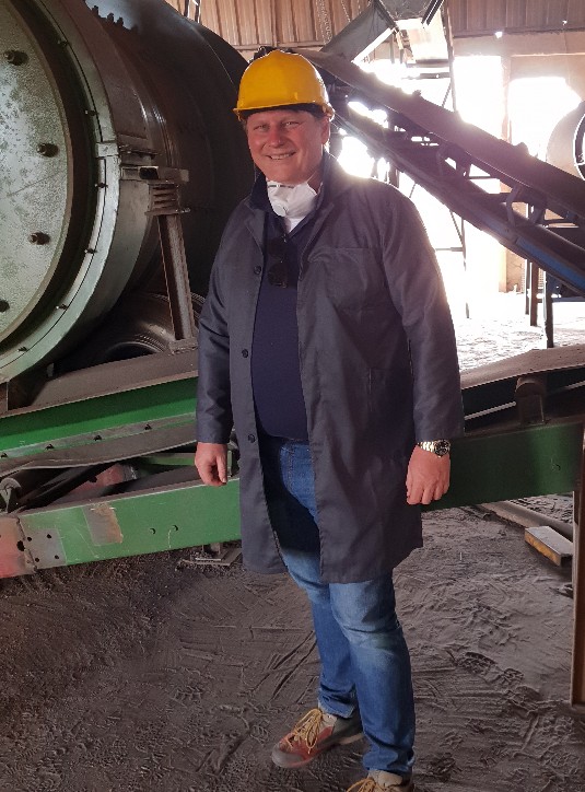 Dr. Jürgen Roth, CEO of Target Trading, standing infront of an industrial machine